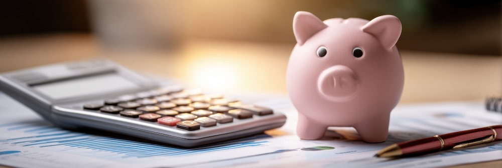 A budget sheet lies alongside a calculator and a piggy bank, illustrating financial management techniques with warm, soft gradient lighting.