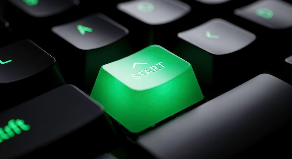 green start button on a computer keyboard. concept of starting or launching something new.