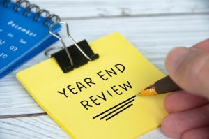 sticky note with year end review written on it. a review reminder.